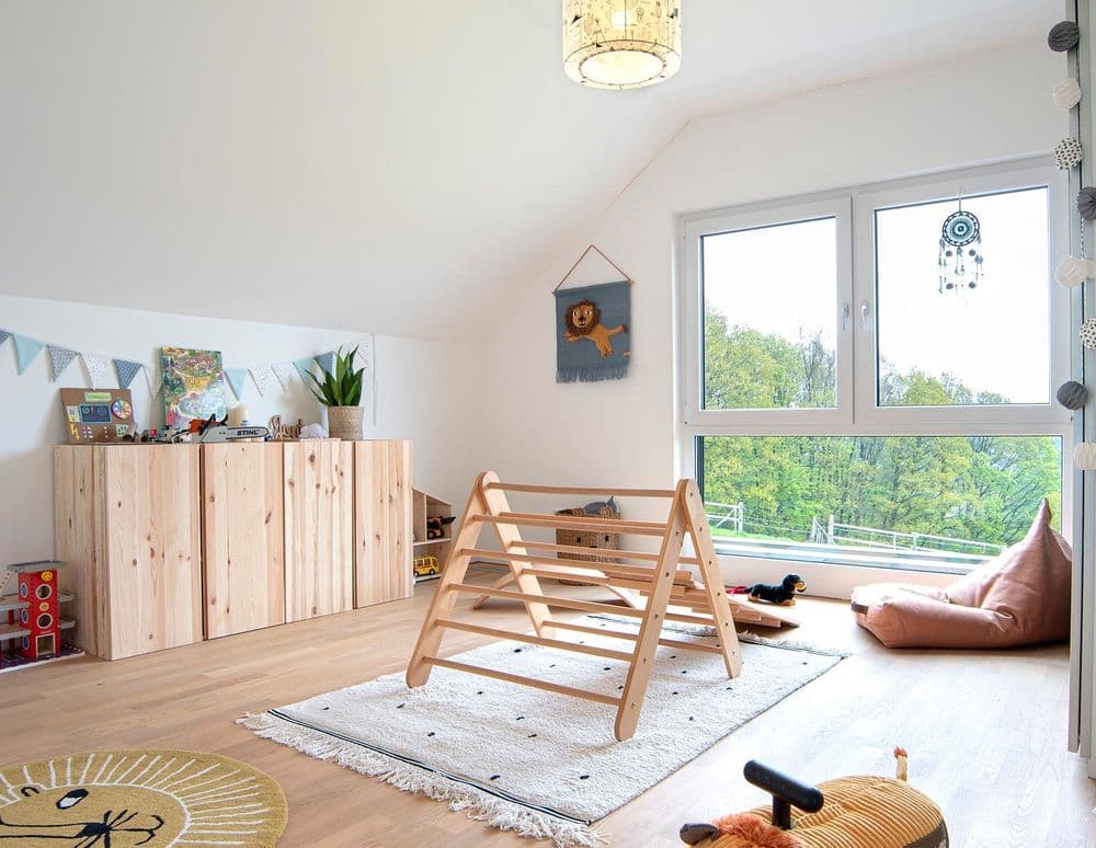 Helles Kinderzimmer mit Holzboden und bodentiefen Fenstern