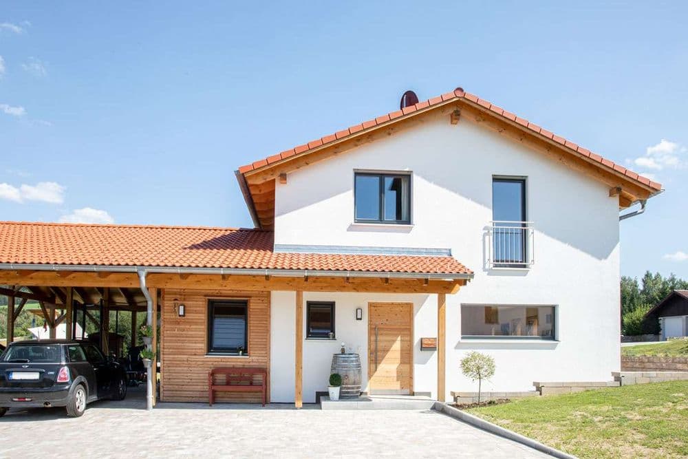 Einfamilienhaus mit überdachtem Eingang und angeschlossenem Carport aus Holz