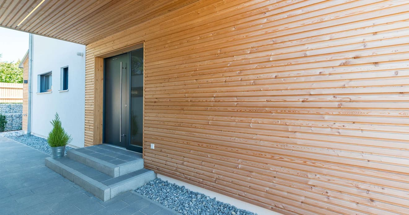 Überdachter Eingangsbereich mit Spritzschutz aus Holz