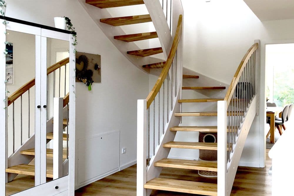 Heller Flur mit verspiegeltem Schrank und Holztreppe