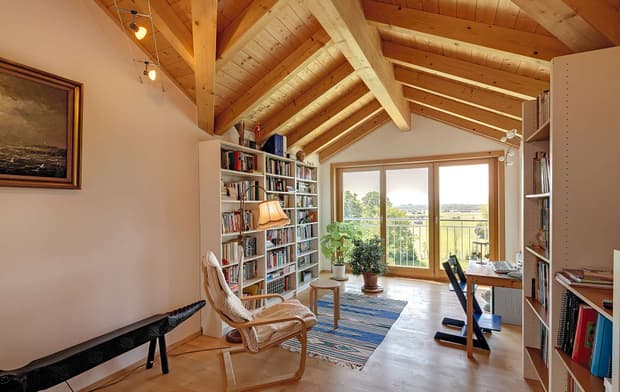 Das Büro des großzügigen Holzhauses im Landhausstil mit Holzfassade und Erker mit mineralischem Außenputz