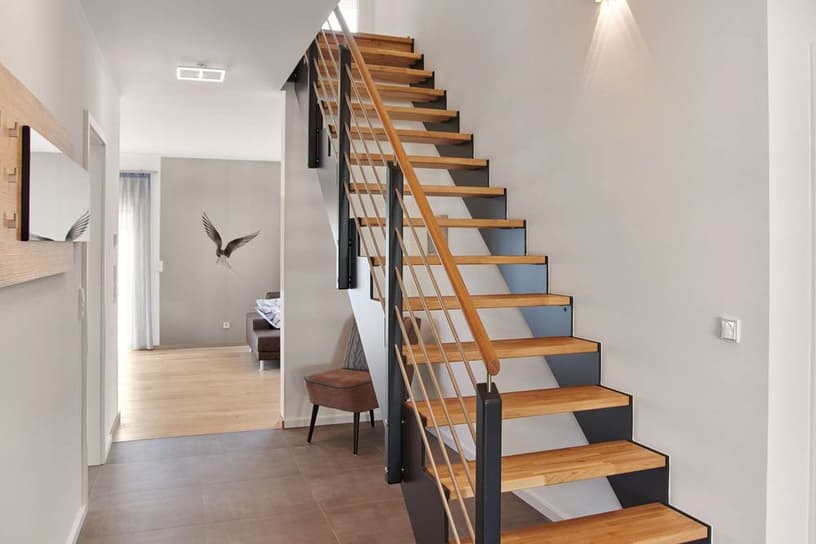 Moderner Eingangsbereich mit offener Holztreppe