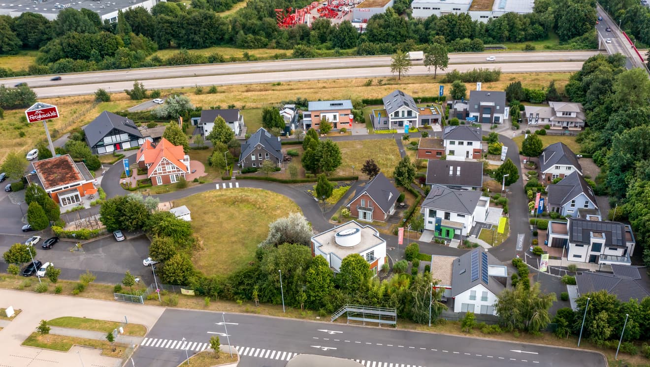 Luftaufnahme eines Musterhausparks mit verschiedenen Fertighäusern in unterschiedlichen Baustilen und Farben