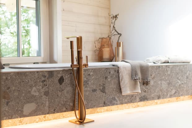 Die messingfarbenen Armaturen im oberen Bad des modernen und großzügigen Holzhauses, bzw. Massivholzhauses im Landhausstil im Musterhauspark in Ortenburg. Der Neubau erinnert an die Chalets im Alpenvorland, hat aber viele moderne Designelemente.
