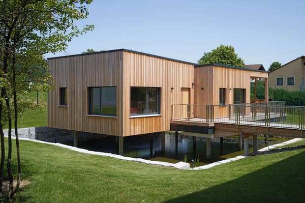Moderner Pfahlbau aus Holz mit vertikaler Lärchenverschalung, der als Mitarbeiterlounge dient