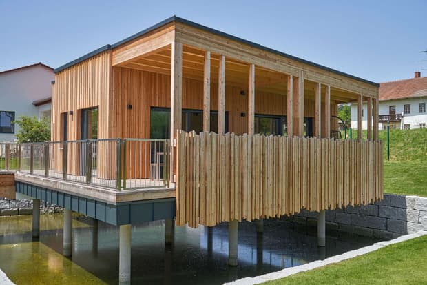 Moderner Pfahlbau aus Holz mit vertikaler Lärchenverschalung, der als Mitarbeiterlounge dient