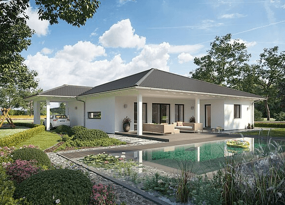 Moderner weißer Bungalow mit dunklem Satteldach Terrasse mit Gartenmöbeln und Schwimmteich im grünen Garten bei Sonnenschein