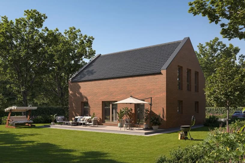 Modernes Musterhaus mit roter Klinkerfassade, Satteldach, Terrasse, Sonnenschirm und gepflegtem Garten mit Sitzbereich.