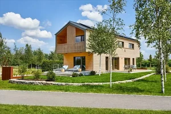 Modernes Holzhaus mit nachhaltiger Architektur und großzügigem Garten. Energieeffizientes Einfamilienhaus in naturnaher Lage mit Terrasse und Birken.