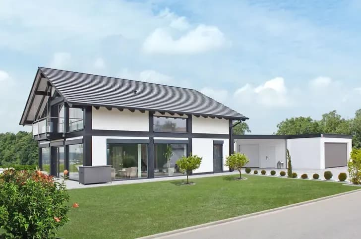 Modernes Einfamilienhaus mit weißer Fassade, großen Fensterflächen und gepflegtem Garten – stilvolle Architektur mit lichtdurchfluteten Räumen.