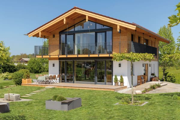 Zweigeschossiges Einfamilienhaus im modernen Alpenstil mit Satteldach, Holzfassade im Obergeschoss und weiß verputztem Erdgeschoss